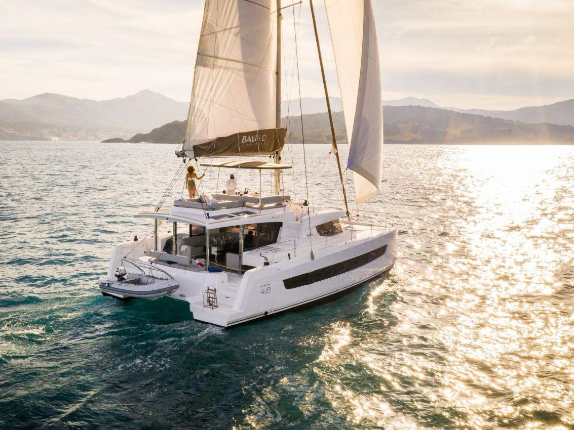 Our catamaran under sail with the coastline behind