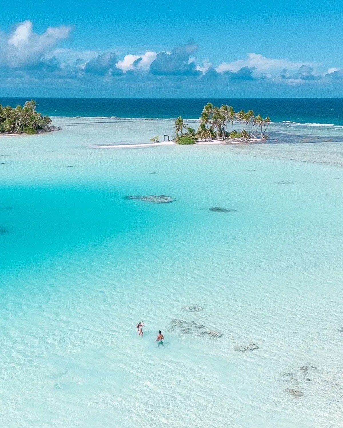 Aerial view of a turquoise lagoon and motu